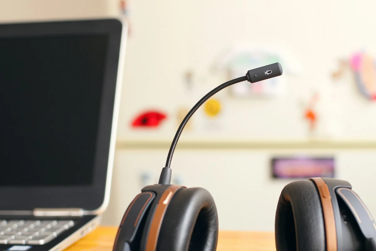 Headset with a microphone next to a laptop