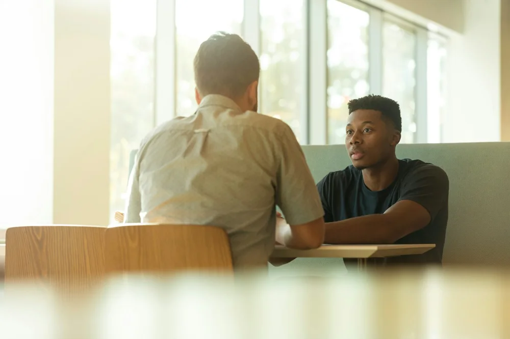 Two professionals talking during a business meeting